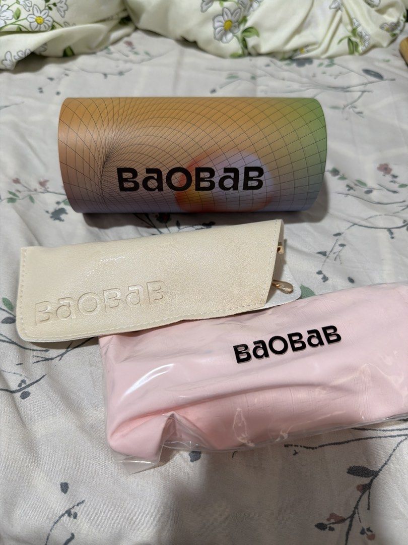 (Take ALL) Baobab Glasses With Case (Category: Sunglasses & Eyewear) located in Muntinlupa City. Submitted by alyssuh_ (Listing ID 1465394450, Image 2). Description: - 2 pairs of Baobab glasses - Frame 1: Thin gold metal frame - Frame 2: Clear frame - Case: Baobab brand cylinder case with colorful gradient grid design - Condition: Never been used.