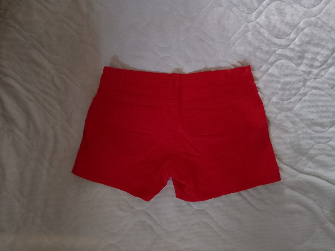 Teomigo Red Shorts Casual Bottoms (Category: Shorts) located in Aroroy. Submitted by itsyviii (Listing ID 1465528397, Image 2). Description: - Brand: Teomigo - Color: Vibrant red - Design: Classic five-pocket style with belt loops and button closure - Special Feature: Unique yellow branded button with a cute character graphic - Condition: Clean front and back, ready to wear - Style: Great pop of color for casual outings and sunny days.