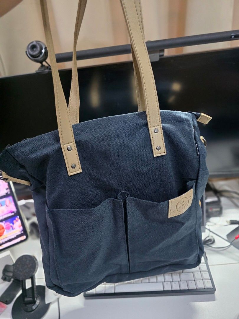 The Coffee Bean and Tea Leaf Canvas Tote Bag (Category: Tote Bags) located in Manila. Submitted by jms_shopping (Listing ID 1465446363, Image 1). Description: - Brand: The Coffee Bean and Tea Leaf - Color: Dark blue canvas with tan faux leather handles and accents - Condition: Brand new with tag still attached to the strap - Closure: Secure top zip closure - Pockets: Convenient front slip pockets with logo patch and interior slip pockets - Extras
