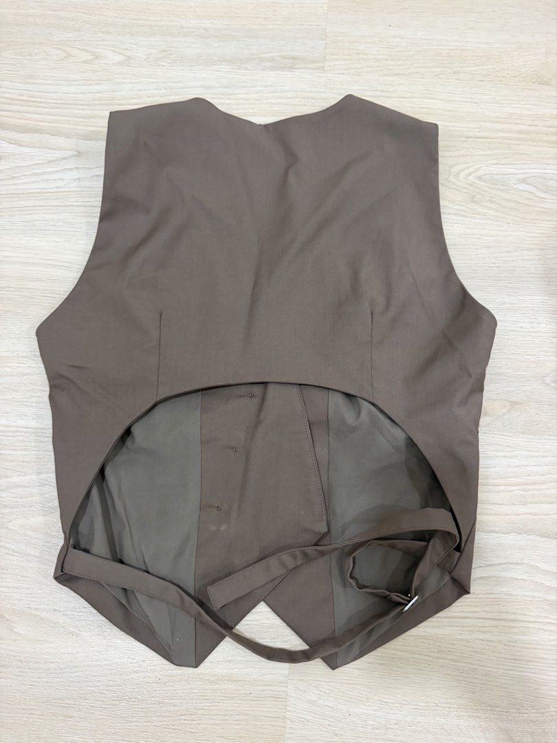 The Editor's Market Brown Open Back Vest (Category: Sleeveless) located in Quezon City. Submitted by closetcleanupsale (Listing ID 1465398086, Image 2). Description: - Brand: The Editor's Market - Style: Brown vest with V-neck, button closure, and two front welt pockets - Back Detail: Unique open back design with adjustable strap and metal buckle - Fit & Fabric: Smooth, structured feel; great for smart casual layering - Condition: Clean, worn onl