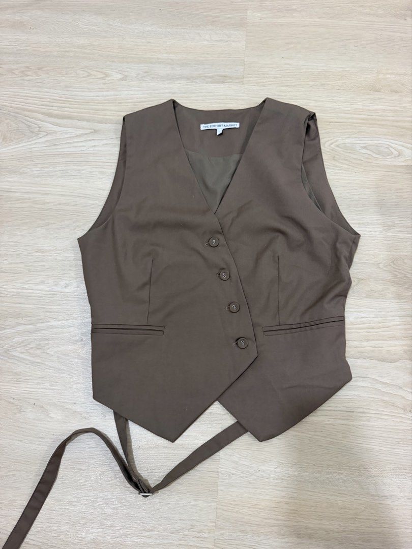The Editor's Market Brown Open Back Vest (Category: Sleeveless) located in Quezon City. Submitted by closetcleanupsale (Listing ID 1465398086, Image 1). Description: - Brand: The Editor's Market - Style: Brown vest with V-neck, button closure, and two front welt pockets - Back Detail: Unique open back design with adjustable strap and metal buckle - Fit & Fabric: Smooth, structured feel; great for smart casual layering - Condition: Clean, worn onl