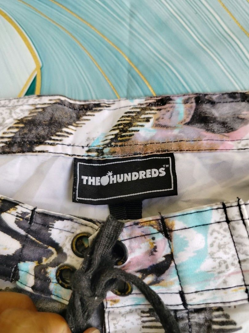 The Hundreds Abstract Print Board Shorts (Category: Swim Trunks & Board Shorts) located in Manila. Submitted by virgiliosa38485 (Listing ID 1465497327, Image 3). Description: - Brand: The Hundreds -Size 34 -Length 21 - Design: Cool black, white, and pastel abstract print with embroidered logo near the hem - Waistband: Secure drawstring design - Pockets: Back pocket with small branded tag and drainage grommets - Fabric: Lightweight and quick-dryin