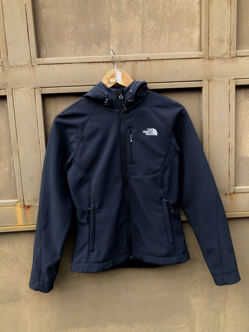 The North Face Black Softshell Hooded Jacket (Category: Coats, Jackets and Outerwear) located in Manila. Submitted by yocsthrifted (Listing ID 1465522685, Image 1). Description: North Face softshell jacket in black. Full zip front, adjustable hood, and zippered chest pocket. Side pockets included for everyday utility. Fleece lining inside for warmth. Clean aesthetic, standard fit, easy to match with daily outfits..