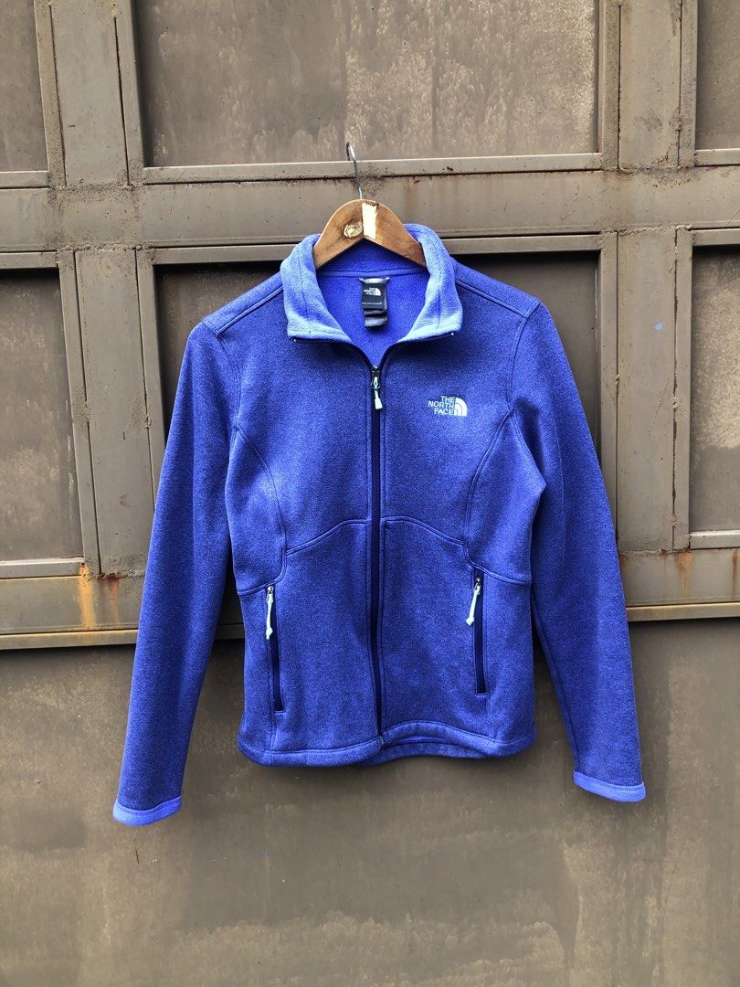 The North Face Purple Fleece Jacket (Category: Coats, Jackets and Outerwear) located in Manila. Submitted by yocsthrifted (Listing ID 1465522529, Image 3). Description: - Brand: The North Face - Color: Heather purple with light blue zipper accents - Material: Soft fleece for reliable warmth in cool weather - Design: Stand collar, full zip-up, regular fit - Storage: Two secure zippered front hand pockets - Branding: Embroidered white logo on the l