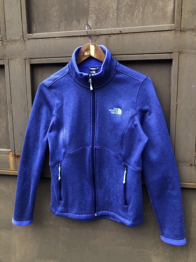 The North Face Purple Fleece Jacket (Category: Coats, Jackets and Outerwear) located in Manila. Submitted by yocsthrifted (Listing ID 1465522529, Image 2). Description: - Brand: The North Face - Color: Heather purple with light blue zipper accents - Material: Soft fleece for reliable warmth in cool weather - Design: Stand collar, full zip-up, regular fit - Storage: Two secure zippered front hand pockets - Branding: Embroidered white logo on the l