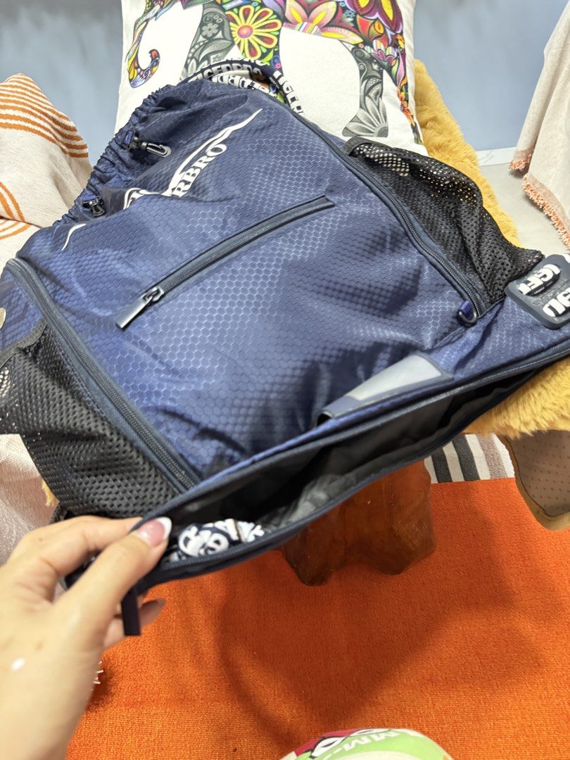 Tigerbro Navy Blue Drawstring Backpack Bag (Category: Backpacks) located in Alaminos. Submitted by jhean1323 (Listing ID 1465449838, Image 3). Description: - Brand: Tigerbro - Color: Navy blue with a large white logo on the front - Material: Honeycomb textured fabric - Compartments: Spacious main interior with inner zip and slip pockets - Pockets: Dual mesh side pockets, front zip pocket, and extra zipped bottom compartment - Straps: Branded shou