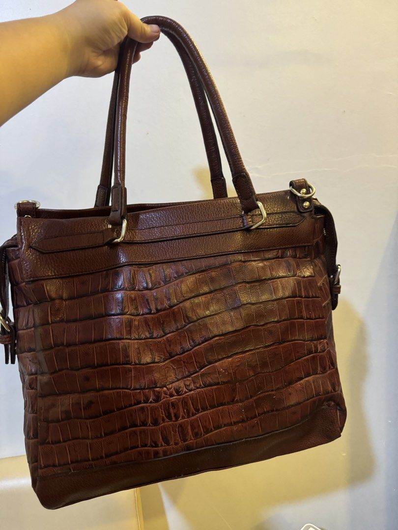 Tod's Brown Crocodile Embossed Leather Tote Bag (Category: Tote Bags) located in Urdaneta. Submitted by kathleenja24136 (Listing ID 1465472019, Image 3). Description: - Authentic Tod's leather handbag in a rich brown shade - Striking crocodile-embossed texture on the lower half - Comfortable dual shoulder straps and elegant gold-tone hardware - Signature debossed Tod's logo patch on the front - Secure zip closure with adjustable buckle strap side