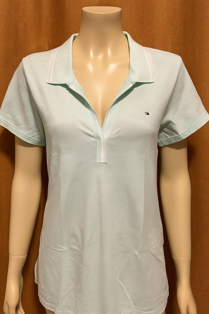 Tommy Hilfiger Light Blue Polo Shirt (Category: Tshirts & Polo Shirts ) located in Manila. Submitted by goldenmoon_f6bc2f (Listing ID 1465478152, Image 2). Description: - Brand: Tommy Hilfiger - Color: Light Blue - Design: Short sleeves, v-neck collar with subtle striped lining, and ribbed sleeve cuffs - Details: Signature small embroidered flag logo on the left chest - Fit: True to size, great casual staple for everyday wear - Condition: Excelle