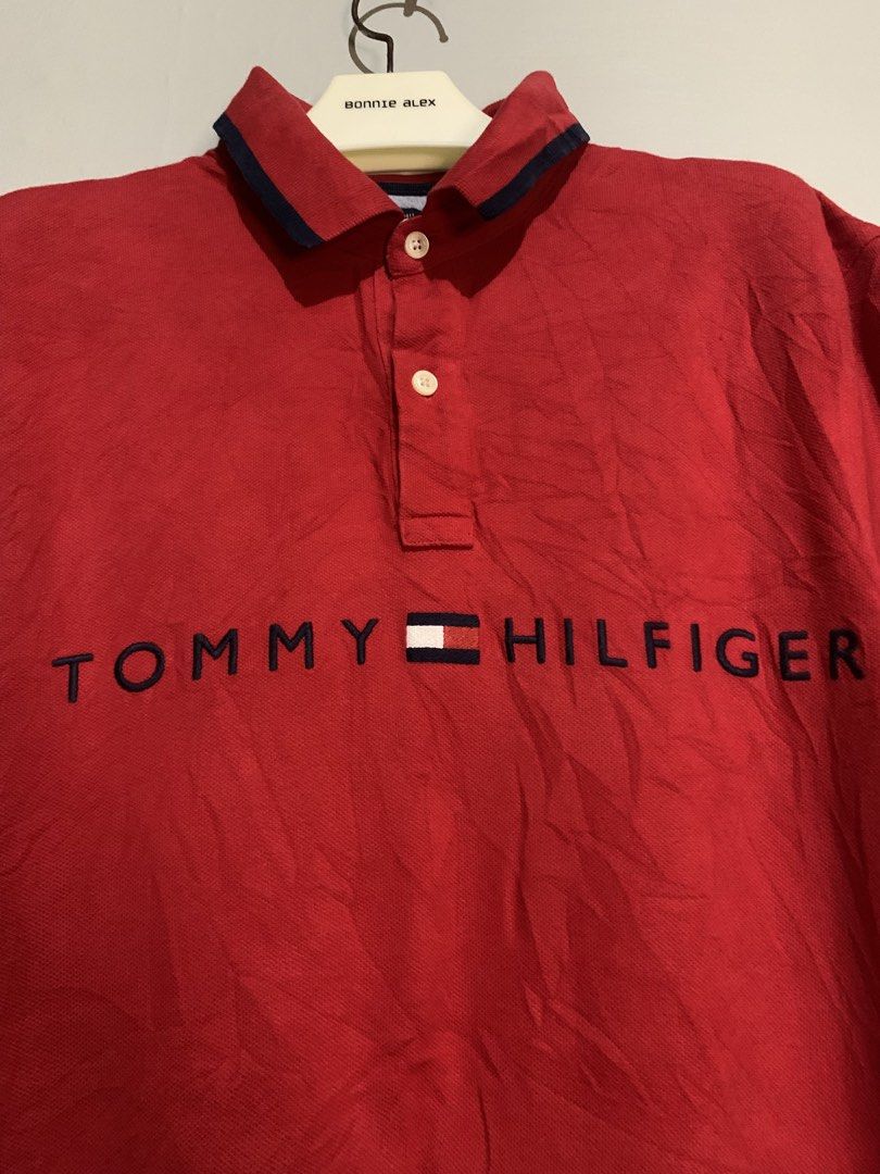 Tommy Hilfiger Red Polo Shirt Medium (Category: Tshirts & Polo Shirts ) located in San Miguel. Submitted by lights_thrifty00 (Listing ID 1465532027, Image 2). Description: - Brand: Tommy Hilfiger - Color: Red with navy blue and white accents - Size: Medium (Classic fit) - Material: 100% Cotton Knit - Details: Big embroidered chest lettering, contrast collar lining, sleeve tipping, branded two-button placket - Origin: Made in Vietnam - Condition: 