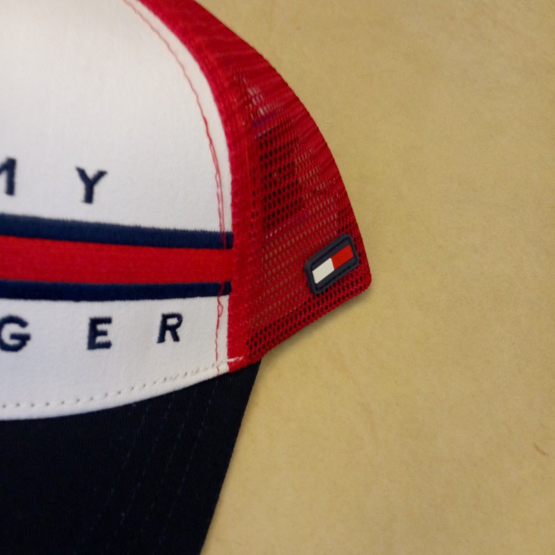 Tommy Hilfiger Trucker Cap Red White Blue (Category: Caps & Hats) located in Manila. Submitted by pablopresk0. (Listing ID 1465503185, Image 2). Description: - Brand: Tommy Hilfiger - Design: Classic tricolor (red, white, and navy blue) with embroidered flag logo on the front - Comfort: Breathable mesh backing and interior branded taping - Fit: Adjustable snapback closure for a custom fit - Condition: Clean brim and crisp stitching throughout - S