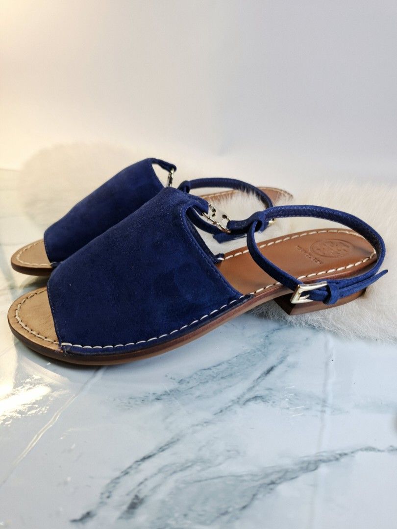 Tory Burch Blue Suede Sandals Size 5M (Category: Flats & Sandals) located in Pasay City. Submitted by onick_79 (Listing ID 1465529639, Image 3). Description: - Brand: Tory Burch - Material: Blue suede upper with brown leather soles and white contrast stitching - Heel: Comfortable low block heel - Closure: Ankle strap with adjustable gold-tone buckle hardware - Branding: Stamped Tory Burch logo on the insole - Condition: Light wear on the bottom s