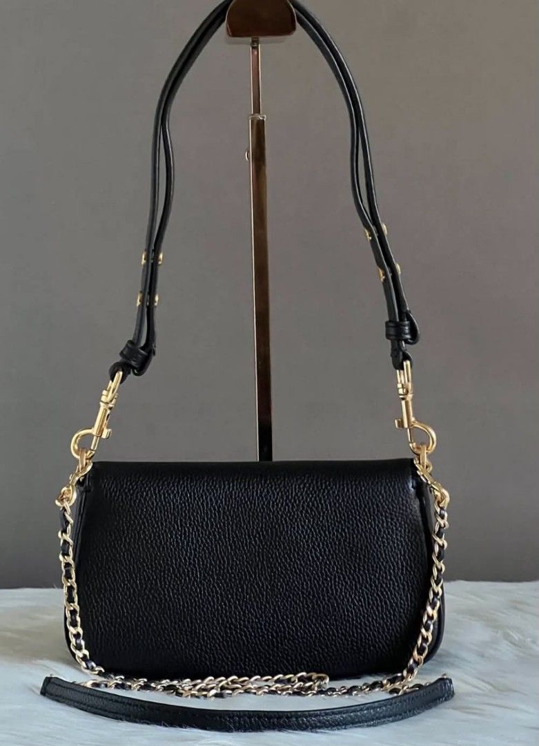 Tory Burch Britten Bag (Category: Shoulder Bags) located in Paoay. Submitted by rvf1230 (Listing ID 1465425385, Image 3). Description: - Brand: Tory Burch - Material: Black pebbled leather with gold hardware - Closure: Front flap with classic double T logo - Straps: Comes with interchangeable chain link strap and adjustable leather shoulder strap - Condition: Brand new with original tag attached, pristine exterior and clean interior.