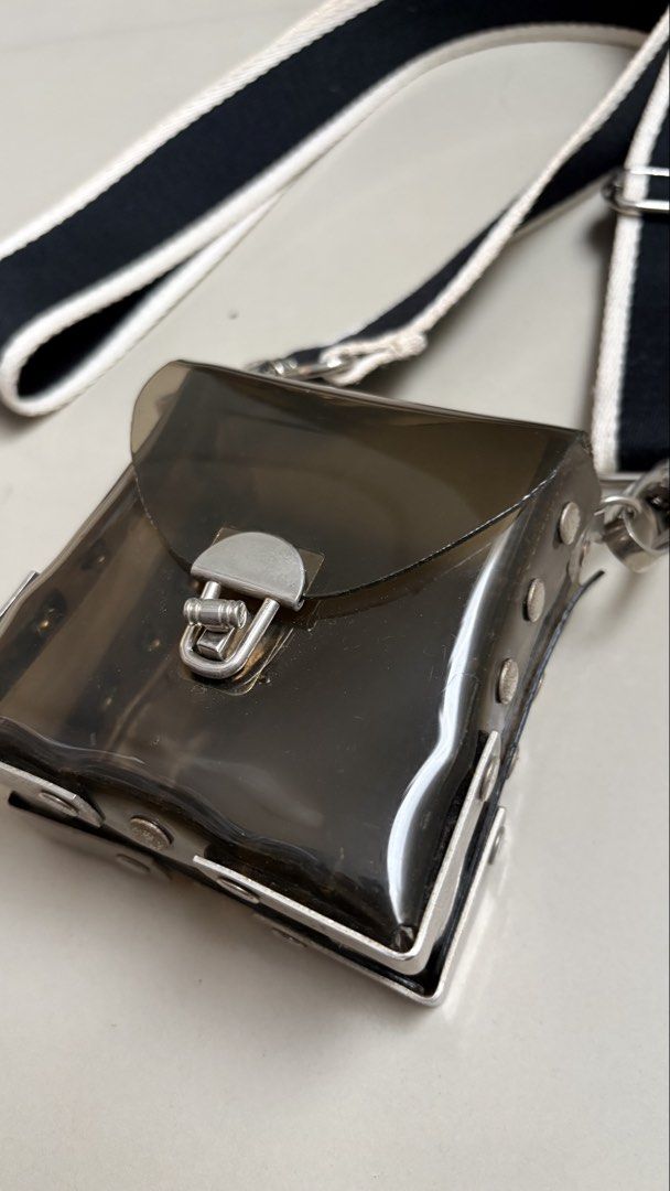 Transparent PVC body bag (Category: Cross-body Bags) located in Binangonan. Submitted by polinn.xx (Listing ID 1465421299, Image 2). Description: transparent small crossbody bag features a dark tinted PVC body paired with a contrasting black-and-white striped webbing strap..
