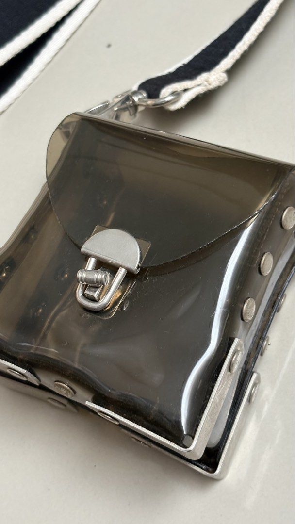Transparent PVC body bag (Category: Cross-body Bags) located in Binangonan. Submitted by polinn.xx (Listing ID 1465421299, Image 3). Description: transparent small crossbody bag features a dark tinted PVC body paired with a contrasting black-and-white striped webbing strap..