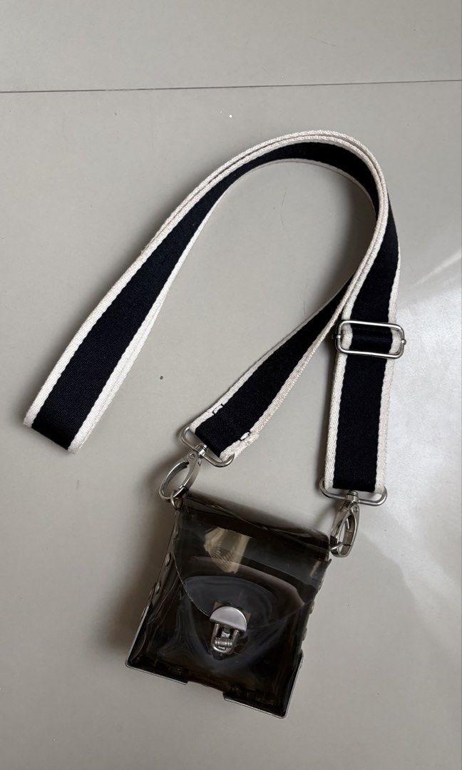Transparent PVC body bag (Category: Cross-body Bags) located in Binangonan. Submitted by polinn.xx (Listing ID 1465421299, Image 1). Description: transparent small crossbody bag features a dark tinted PVC body paired with a contrasting black-and-white striped webbing strap..