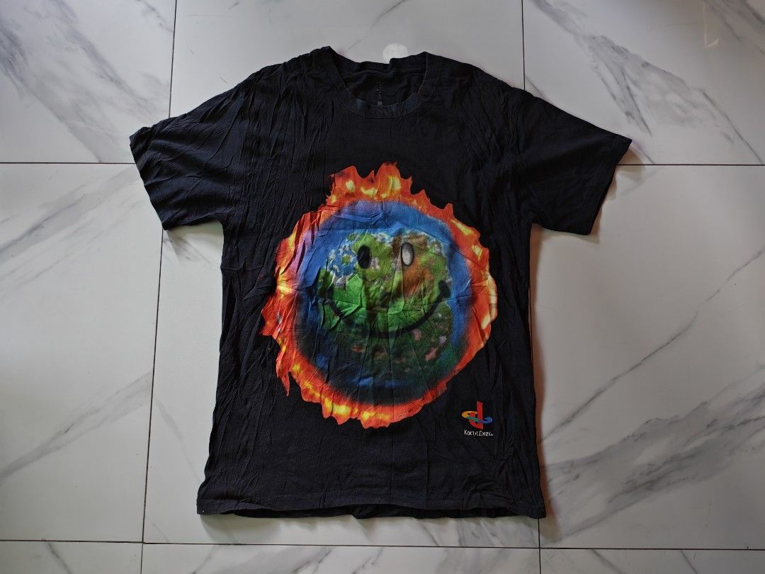 Travis Scott Cactus Jack PlayStation T-Shirt (Category: Tshirts & Polo Shirts ) located in Davao. Submitted by thrift2you (Listing ID 1465420913, Image 1). Description: - Item: Travis Scott Cactus Jack x PlayStation Tee - Color: Faded Black (washed look) - Size: Medium - Design: Large burning globe front graphic, PlayStation/Cactus Jack branding and 'Live in your world, RAGE in ours.' text on back - Material: 100% Cotton, Made in Mexico (© 2020 L