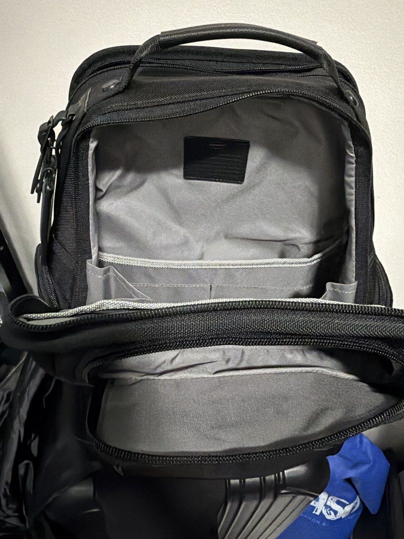 TUMI Alpha 3 backpack (Category: Backpacks) located in Pasig City. Submitted by xublime.cloud (Listing ID 1465485341, Image 2). Description: - Brand: TUMI - Color: Classic Black - Material: Rugged, durable ballistic nylon - Compartments: Multiple front zippered pockets for easy access - Interior: Grey fabric lining with built-in organizer slip pockets and card slots - Handle: Top carry handle featuring a stylish leather wrap detail - Accent: Sign