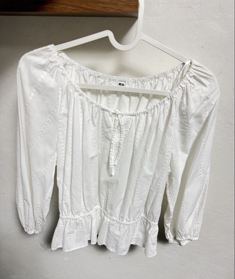 Uniqlo White Peasant Blouse Size S (Category: Blouses) located in Marikina City. Submitted by meandmyprelovedstuff (Listing ID 1465208880, Image 2). Description: - Brand: Uniqlo - Size: S (tag attached) - Color: White - Design: Square neckline with front tie, subtle eyelet embroidery stripes, and long sleeves with elastic cuffs - Fit: Smocked waist with a flattering flared peplum hem Fits S-M frames Color rate: 8/10 No issues Needs wash.