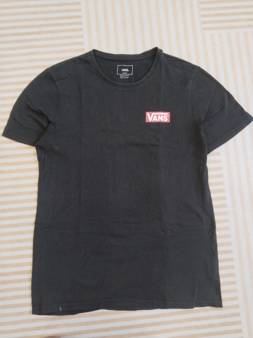 Vans Off The Wall Black T-Shirt (Category: Tshirts & Polo Shirts ) located in Manila. Submitted by polding25 (Listing ID 1465386490, Image 3). Description: Black short-sleeve t-shirt from Vans. Small red box logo on the front chest. Large graphic print on the back with Vans Off The Wall branding. Regular fit crew neck style. Measurements approx 20.5 inches chest by 28 inches length. Tag shows size details and care instructions inside..