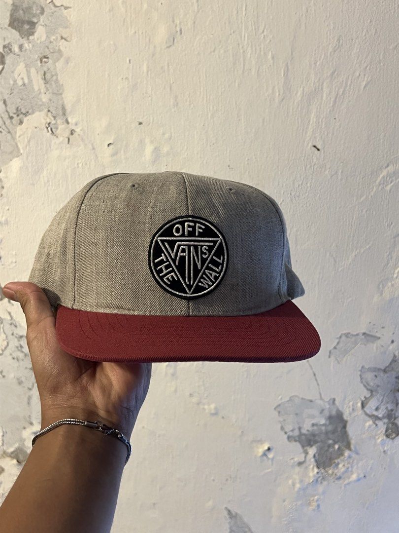 Vans Off The Wall Snapback Cap Grey Maroon (Category: Caps & Hats) located in Manila. Submitted by maccabeyo (Listing ID 1465412290, Image 1). Description: - Brand: Vans - Color: Grey and maroon - Design: Classic Off The Wall embroidered circular patch logo on the front - Fit: Adjustable black plastic strap closure at the back - Details: Woven Vans logo tag on the side, clean structured crown, and flat brim - Condition: Brand new / Excellent pre-