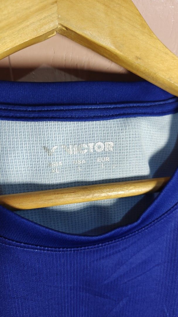 Victor Badminton Jersey Blue (Category: Activewear) located in San Francisco. Submitted by Intaw20 (Listing ID 1465532969, Image 3). Description: - Brand: Victor - Color: Blue with abstract graphics and pink chest logo - Size: Asia XL (USA/EUR L) - Material: Lightweight, moisture-wicking polyester - Origin: Made in Taiwan - Condition: Clean, well-kept, and ready to wear - Ideal for: Badminton, gym workouts, and athletic training.