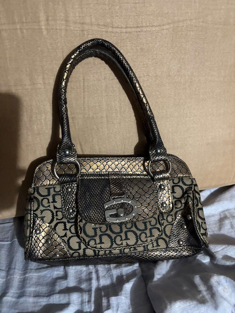 Vintage Guess Snake Print hand bag (Category: Shoulder Bags) located in Manila. Submitted by benishark28 (Listing ID 1465492263, Image 1). Description: - Brand: Guess - Color/Design: Metallic gold and black with snake skin texture and signature logo pattern - Hardware: Silver-tone metal accents with a large letter buckle on the front flap - Pockets: Convenient front flap pocket - Straps: Dual structured straps for comfortable wear - Size & Style: