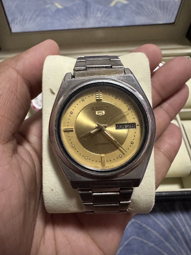 Vintage Seiko 5 Automatic Gold Dial Watch (Category: Men's Watches) located in Manila. Submitted by zealdeer_4239a8 (Listing ID 1465546069, Image 1). Description: - Model: Vintage Seiko 5 Automatic Watch - Dial: Classic gold dial with day and date display at the 3 o'clock position - Materials: Stainless steel case and bracelet with a signed Seiko clasp - Movement: Automatic (keeps ticking reliably) - Condition: Noticeable scratches on the crystal