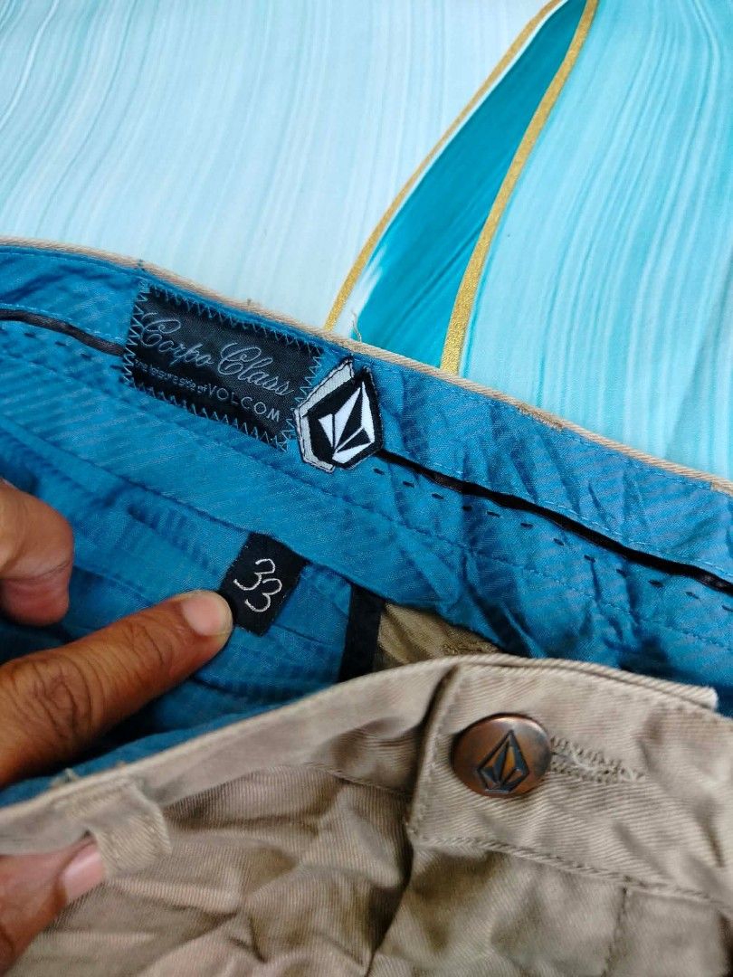 Volcom Corpo Class Men's Beige Shorts Size 33 (Category: Shorts) located in Manila. Submitted by virgiliosa38485 (Listing ID 1465502580, Image 2). Description: - Brand: Volcom - Color: Beige with teal inner waistband lining - Size: Tagged 33-34 -Length 21.5 - Closure: Button fly - Pockets: Front/back welt pockets and small side utility pocket - Details: Embroidered Volcom stone logo on lower leg and back pocket - Style: Casual wear.
