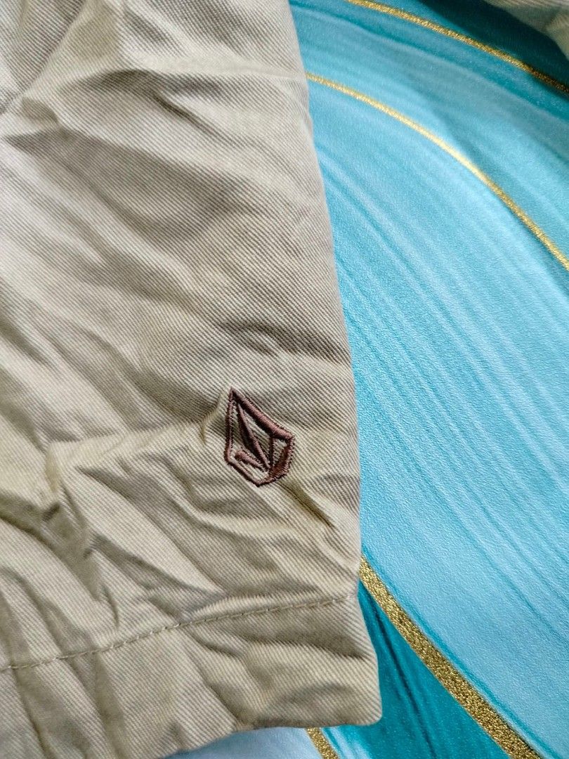 Volcom Corpo Class Men's Beige Shorts Size 33 (Category: Shorts) located in Manila. Submitted by virgiliosa38485 (Listing ID 1465502580, Image 3). Description: - Brand: Volcom - Color: Beige with teal inner waistband lining - Size: Tagged 33-34 -Length 21.5 - Closure: Button fly - Pockets: Front/back welt pockets and small side utility pocket - Details: Embroidered Volcom stone logo on lower leg and back pocket - Style: Casual wear.