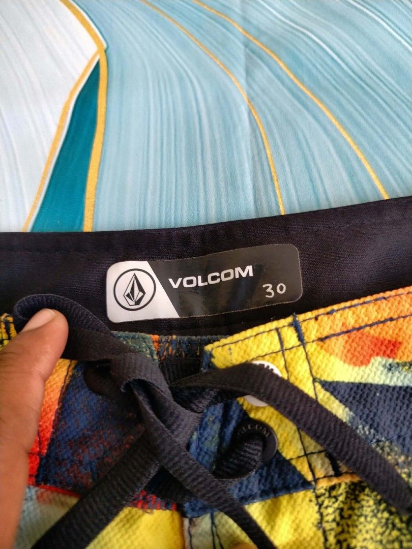 Volcom Multi-color Abstract Print Boardshorts Size 30 (Category: Swim Trunks & Board Shorts) located in Manila. Submitted by virgiliosa38485 (Listing ID 1465496072, Image 2). Description: - Brand: Volcom - Size: 30 (inner waistband tag) -Waist 30-32 -Length 19 - Color/Design: Bold abstract print in yellow, orange, and navy blue - Features: Front drawstring closure, back pocket with Volcom patch, and branded patch on the left leg - Condition/Style