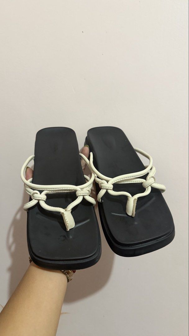 Waa. Tangled Sandals (Category: Flats & Sandals) located in Limay. Submitted by nimfalorraine (Listing ID 1465396378, Image 1). Description: - Brand: Waa. - Size: 39 (Made in Vietnam) - Color: Classic Black & White - Style: Minimalist slip-on thong sandals with white tubular straps and trendy knot details - Sole: Flat with textured rubber bottom for anti-slip grip - Condition: Good, with minor wear on the white strap material near the knots.