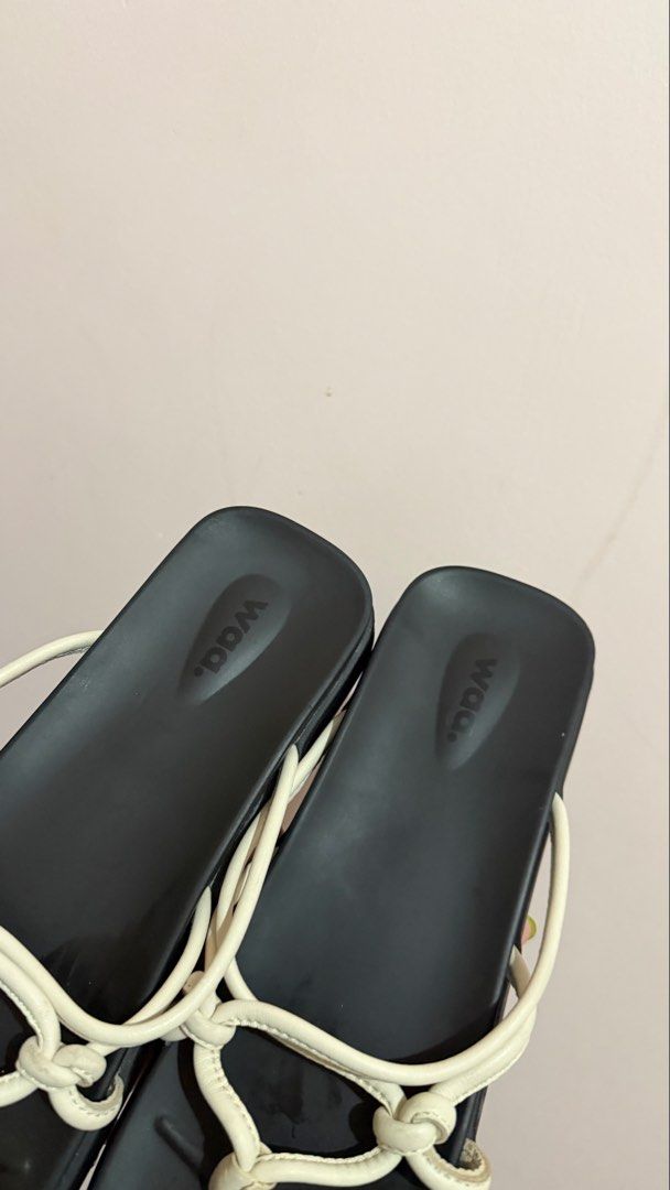 Waa. Tangled Sandals (Category: Flats & Sandals) located in Limay. Submitted by nimfalorraine (Listing ID 1465396378, Image 2). Description: - Brand: Waa. - Size: 39 (Made in Vietnam) - Color: Classic Black & White - Style: Minimalist slip-on thong sandals with white tubular straps and trendy knot details - Sole: Flat with textured rubber bottom for anti-slip grip - Condition: Good, with minor wear on the white strap material near the knots.