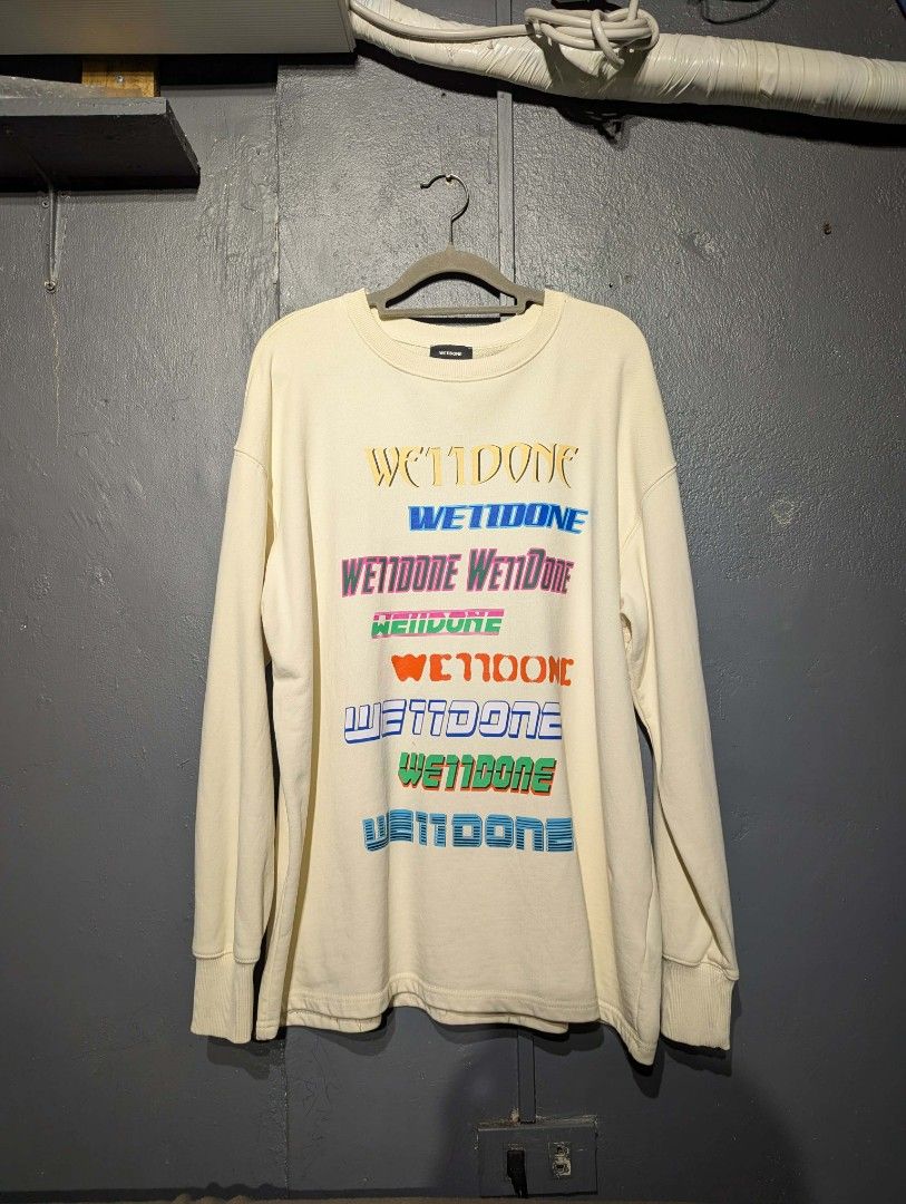 We11done Multi Logo Long Sleeve Sweatshirt Off-White Size M (Category: Coats, Jackets and Outerwear) located in Manila. Submitted by grandwater.53a8ce (Listing ID 1465489415, Image 1). Description: - Brand: We11done - Color: Cream / Off-white - Size: Medium (M) - Material: 100% Cotton shell - Design: Colorful stacked typography prints on the front, with ribbed collar, cuffs, and hem - Authenticity: Includes Certilogo tag.