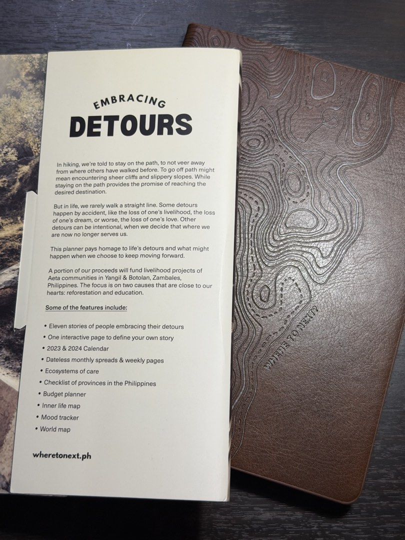 Where To Next Planner Embracing Detours (Category: Stationery & School Supplies) located in Manila. Submitted by seamsmeup9.9 (Listing ID 1465533482, Image 2). Description: - Where To Next planner with brown faux leather topo cover and sleeve - Includes 2023/2024 calendars, dateless monthly/weekly pages, budget planner, mood tracker, world map, and 11 inspiring stories - Purpose-driven: Part of proceeds fund Aeta communities in Zambales, PH.