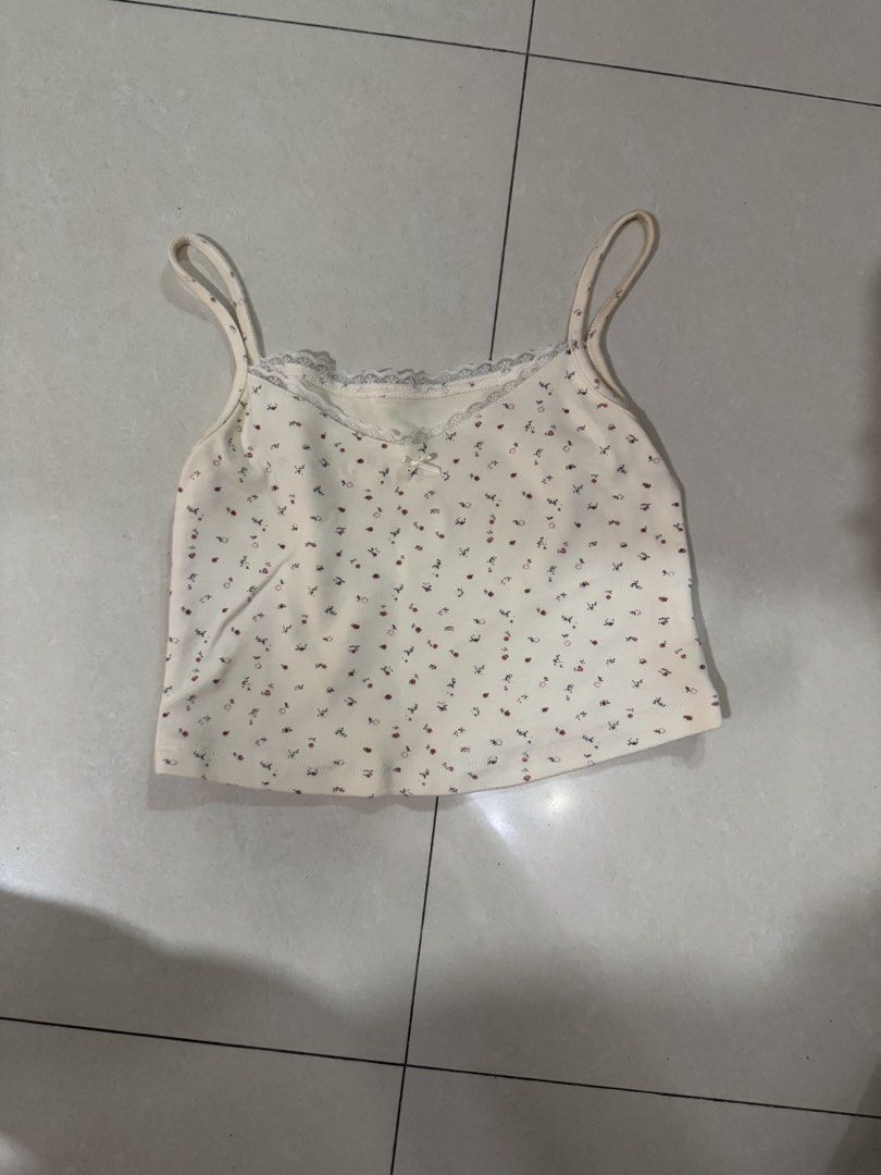 Whimsy Floral Cami Top with Lace Trim (Category: Sleeveless) located in Quezon City. Submitted by sweetlyluxe (Listing ID 1465499292, Image 1). Description: - Color/Pattern: Cream with all-over tiny floral print - Details: Scalloped lace trim, cute center bow, soft ribbed texture - Fit: Cropped length with adjustable spaghetti straps - Styling: Pairs perfectly with high-waisted jeans or skirts ).