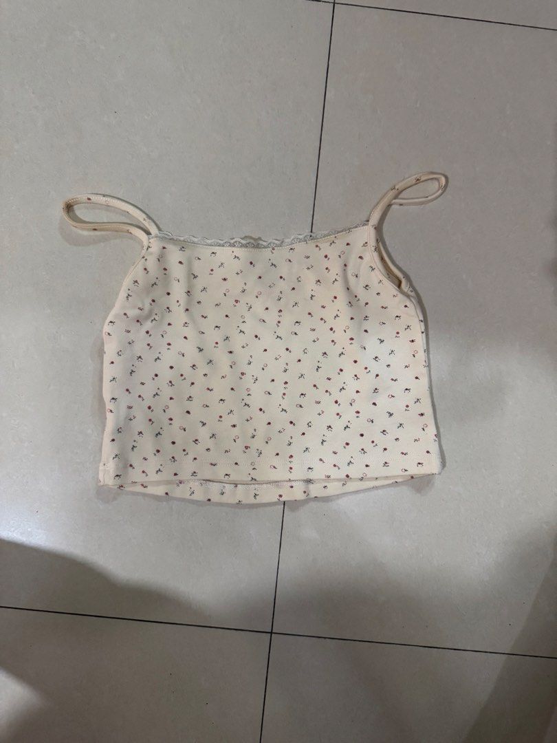 Whimsy Floral Cami Top with Lace Trim (Category: Sleeveless) located in Quezon City. Submitted by sweetlyluxe (Listing ID 1465499292, Image 2). Description: - Color/Pattern: Cream with all-over tiny floral print - Details: Scalloped lace trim, cute center bow, soft ribbed texture - Fit: Cropped length with adjustable spaghetti straps - Styling: Pairs perfectly with high-waisted jeans or skirts ).