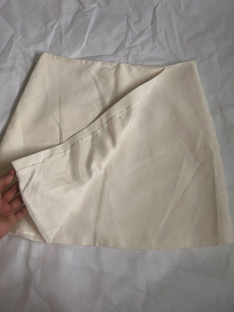 White asymmetrical wrap-style mini skirt (Category: Skirts) located in Imus. Submitted by donnasaurr19 (Listing ID 1465427624, Image 2). Description: Size: W-15 / L-16 Condition: 8/10 RFS: Decluttering Issue: unnoticeable stain inside the skirt due to stuck.