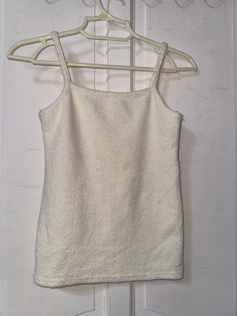White fuzzy knit cami tank top (Category: Sleeveless) located in Santa Ana. Submitted by fatikilla (Listing ID 1465391445, Image 2). Description: - Color: White - Material: Soft, fuzzy knit fabric - Design: Square neckline with thin spaghetti straps - Versatile: Great for layering or wearing solo - Easy to style: Pairs perfectly with denim or skirts.