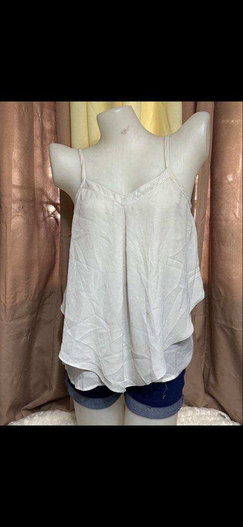 White Layered Camisole Spaghetti Strap Top (Category: Sleeveless) located in Marikina City. Submitted by lorradel (Listing ID 1465393618, Image 1). Description: - Color: White - Style: V-neck spaghetti strap top with layered flowy fabric - Fit: Comfortable elasticized band across the back - Straps: Adjustable thin straps - Material: Lightweight, perfect for warm weather or layering - Styling: Great to pair with denim shorts or jeans for a casual 