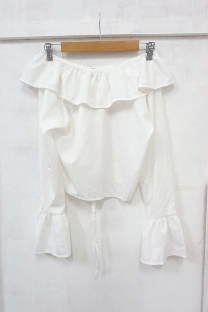 White Off Shoulder Long Sleeve Ruffle Blouse Top (Category: Blouses) located in Quezon City. Submitted by theusualneed (Listing ID 1465444094, Image 3). Description: - Color: Clean white - Style: Off-shoulder with long bell sleeves - Details: Ruffle neckline trim and adjustable tie at the hemline - Fabric: Lightweight and comfortable - Versatility: Easy to pair with your favorite jeans or skirts, ideal for casual days or dates.