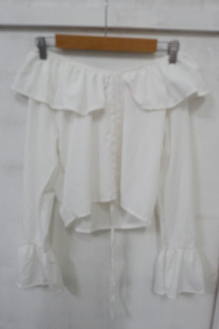 White Off Shoulder Long Sleeve Ruffle Blouse Top (Category: Blouses) located in Quezon City. Submitted by theusualneed (Listing ID 1465444094, Image 2). Description: - Color: Clean white - Style: Off-shoulder with long bell sleeves - Details: Ruffle neckline trim and adjustable tie at the hemline - Fabric: Lightweight and comfortable - Versatility: Easy to pair with your favorite jeans or skirts, ideal for casual days or dates.