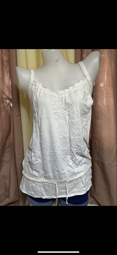 White Tank Top with Ruffle Neckline and Drawstring Hem (Category: Sleeveless) located in Marikina City. Submitted by lorradel (Listing ID 1465393517, Image 1). Description: - Color: White - fits M- L - Material: Lightweight cotton fabric - Design: Ruffled neckline with thick straps - Feature: Adjustable drawstring detail near the bottom hem - Style: Simple and casual, ideal for hot weather or layering under cardigans - might have washable stain d