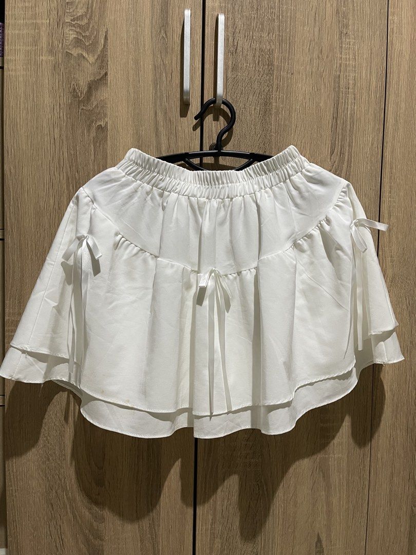 White tiered mini skirt with ribbon bows (Category: Skirts) located in Manila. Submitted by preloveditems_jem (Listing ID 1465475113, Image 1). Description: Super cute white mini skirt with double-layered ruffles, playful ribbon bows, and a comfy elastic waistband. Made of light, soft fabric and very stretchy. Please note there are minor yellowish stains near the bottom hem!.