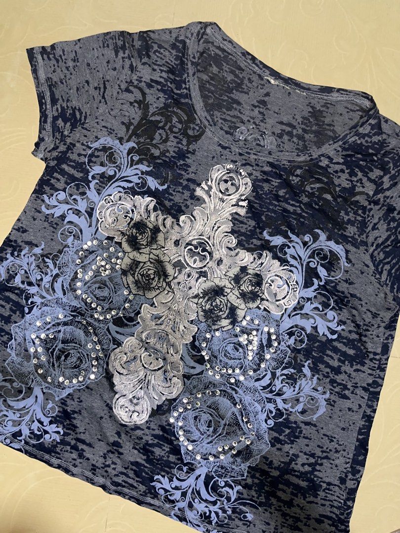 Y2K Grunge Cross Rhinestone Graphic Tee (Category: Shirts) located in Dagupan City. Submitted by shanadongsb (Listing ID 1465524103, Image 1). Description: - Dark grey and blue acid wash short sleeve t-shirt with a worn-in marbled look - Features a large silver glitter cross surrounded by blue roses and rhinestones - Scoop neckline and soft, comfortable fabric - Great for layering and casual streetwear outfits.