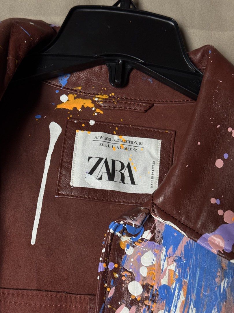 Zara A/W 2021 Collection Paint Splatter Leather Jacket (Category: Coats, Jackets and Outerwear) located in Manila. Submitted by seangoart (Listing ID 1465513189, Image 2). Description: - Brand: Zara (Autumn/Winter 2021 Collection) - Style: Brown faux leather jacket with bold, all-over paint splatter design (white, blue, pink, orange, purple) - Size: Large - Features: Front button closure and adjustable drawstring hem - Condition: Excellent statem