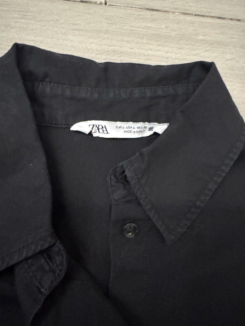 Zara Black Button-Up Shirt With Studded Pockets (Category: Shirts) located in Taguig. Submitted by sqaumejada (Listing ID 1465415889, Image 2). Description: - Brand: Zara - Size: L - Color: Classic Black - Details: Long sleeves with button cuffs, standard collar, and two chest pockets accented with small metal studs - Hem: Curved hemline, slightly longer in the back - Origin: Made in Turkey - Style: Casual with an edgy twist.
