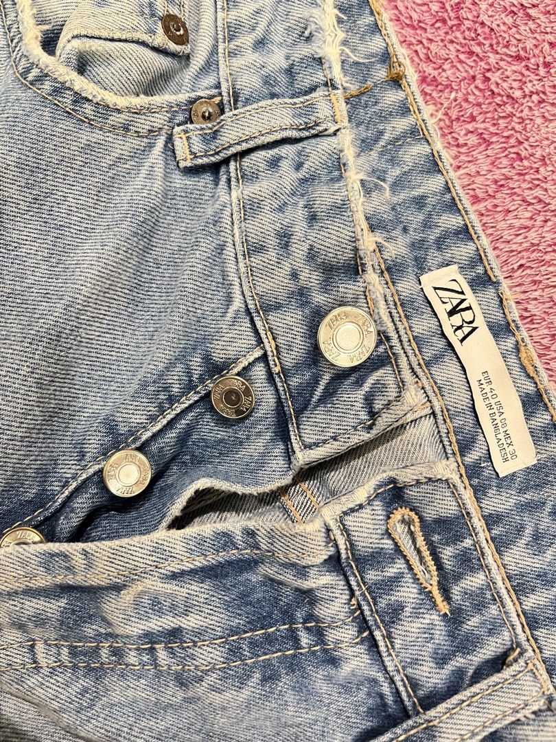Zara Light Wash Button Fly Distressed Jeans Size 30 (Category: Jeans) located in Las Pinas. Submitted by francesaly (Listing ID 1465463397, Image 2). Description: Zara light wash denim jeans. Straight leg fit with distressed raw edges at the waistband and hems. Button-fly closure with metallic buttons. Five pocket styling with standard back pockets. Size EUR 40, USA 30, MEX 30 on tag. Medium blue tone with subtle fading along the front thighs..