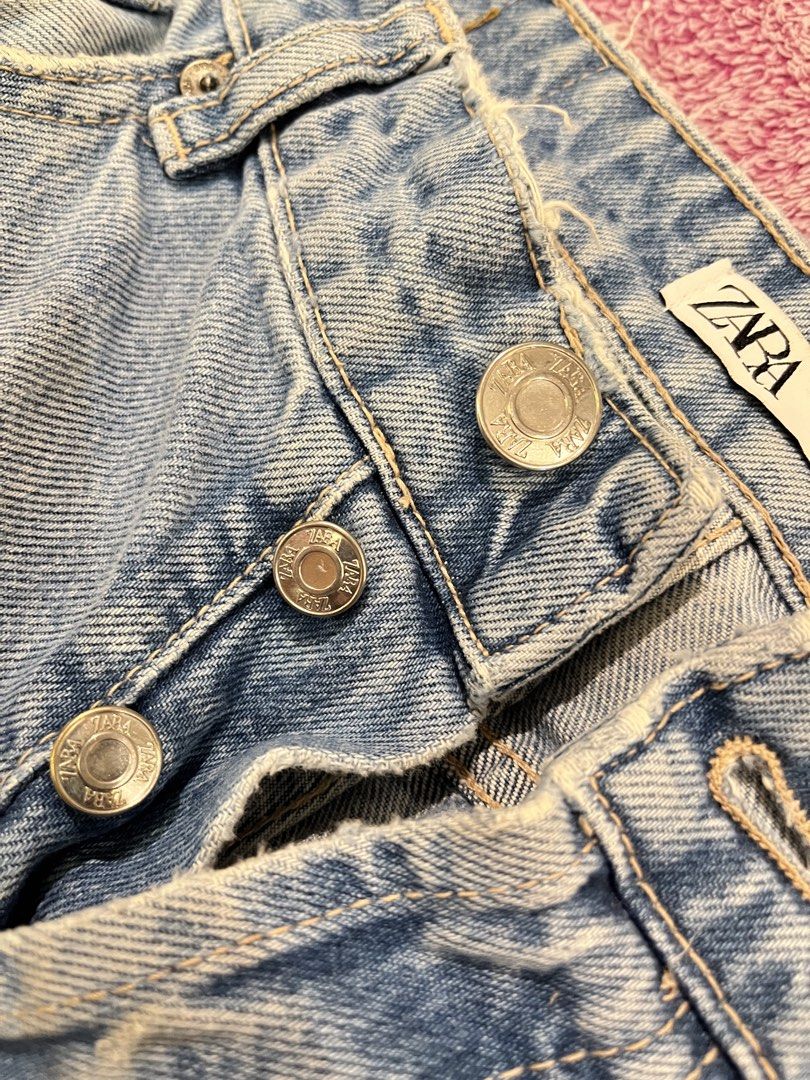 Zara Light Wash Button Fly Distressed Jeans Size 30 (Category: Jeans) located in Las Pinas. Submitted by francesaly (Listing ID 1465463397, Image 3). Description: Zara light wash denim jeans. Straight leg fit with distressed raw edges at the waistband and hems. Button-fly closure with metallic buttons. Five pocket styling with standard back pockets. Size EUR 40, USA 30, MEX 30 on tag. Medium blue tone with subtle fading along the front thighs..