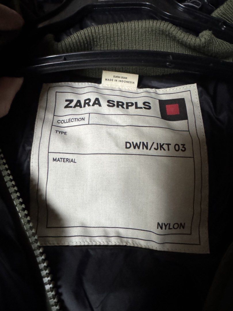 Zara Srpls Down Jacket 03 Nylon Black Olive Green (Category: Coats, Jackets and Outerwear) located in Manila. Submitted by seangoart (Listing ID 1465500446, Image 2). Description: - Brand: Zara SRPLS (DWN/JKT 03) - Color: Glossy black with olive green contrast panels - Features: Hooded design, zip-up front, secure interior pocket, and ribbed knit cuffs - Style: Military surplus aesthetic, trendy winter outerwear - Origin: Made in Indonesia - Cond