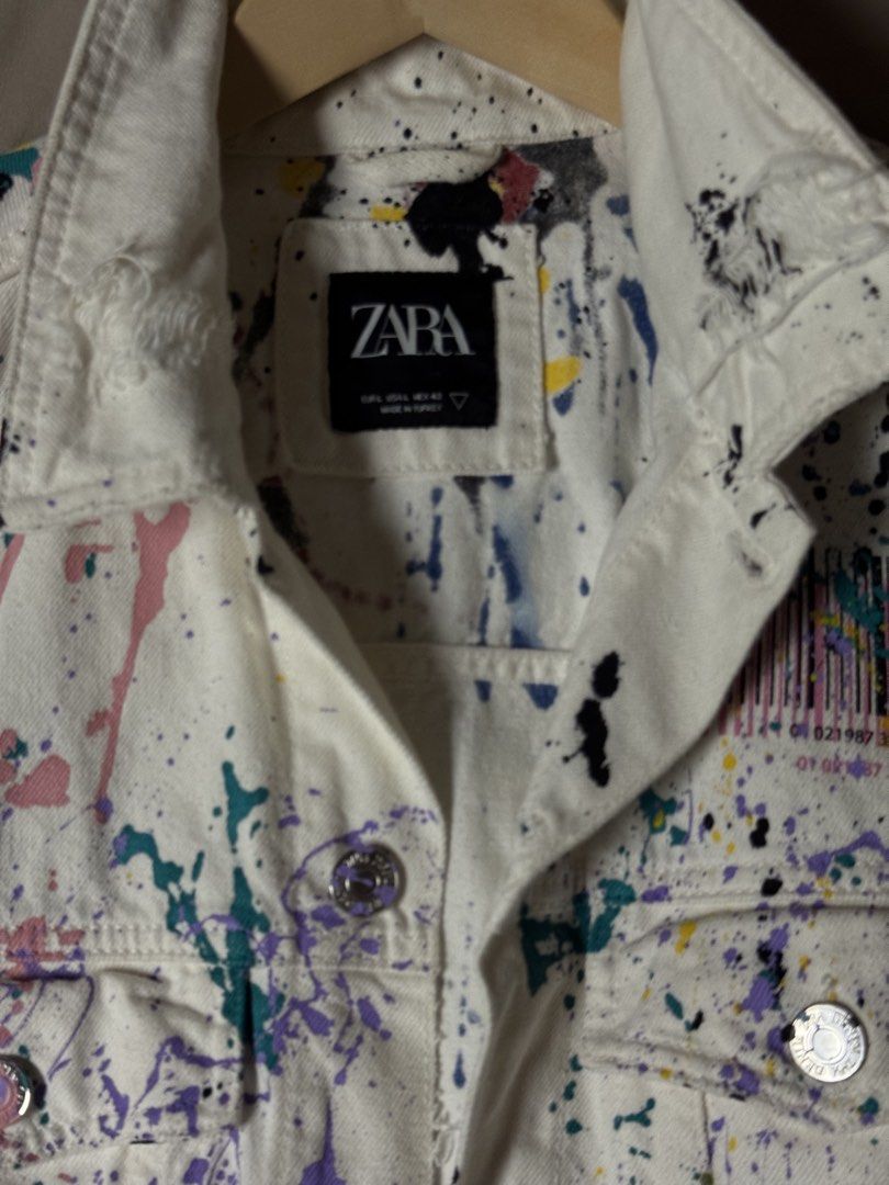 Zara White Paint Splatter Denim Jacket Size L (Category: Coats, Jackets and Outerwear) located in Manila. Submitted by seangoart (Listing ID 1465511366, Image 2). Description: Zara denim jacket in white with multi-color paint splatter design all over. Distressed details on collar, cuffs, and hem. Metal button closure down the front, dual chest pockets with button flaps, side slip pockets. Size EUR L, USA L, MEX 42. Made in Turkey. Standout statem